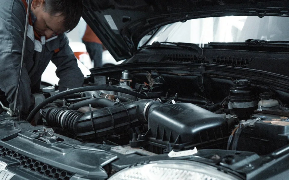 Mechanic inspecting a car's engine bay.