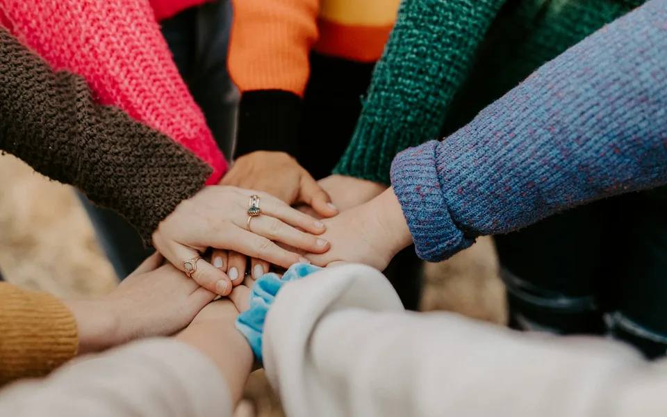 Community members stacking their hands in a group.