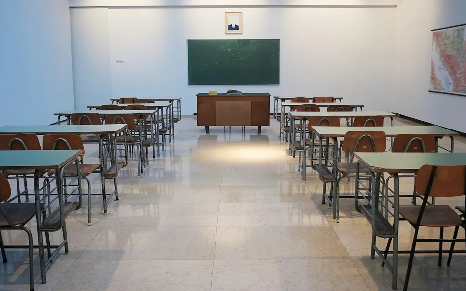 Desks and chalkboard in a school classroom.