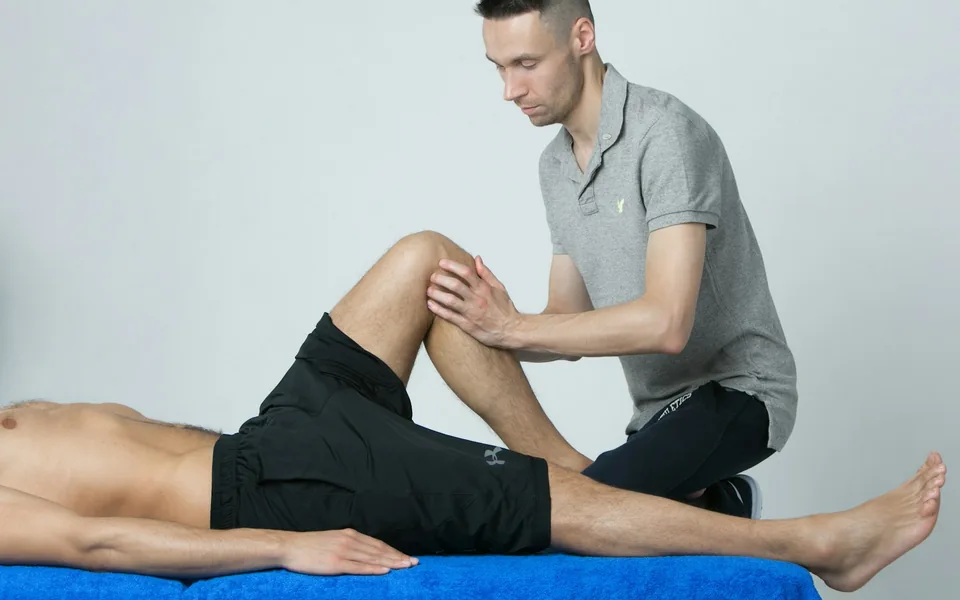 Therapist examining a patient's knee.